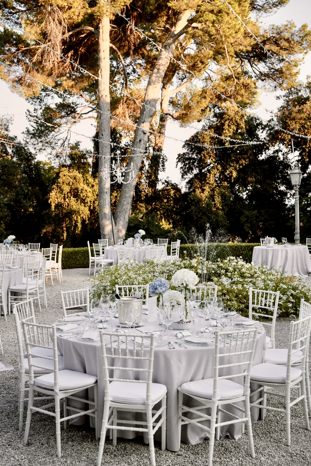 Ricevimento di matrimonio con tavoli bianchi e fontana